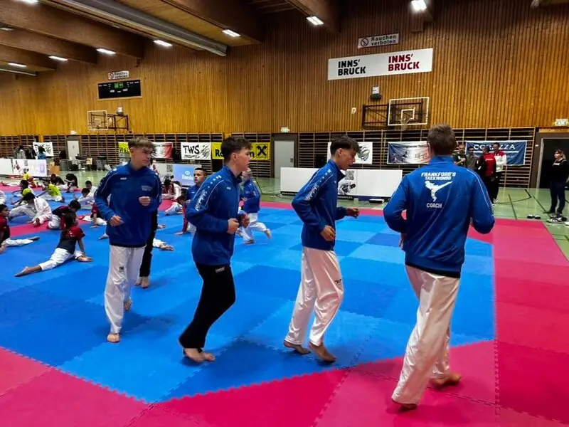 Unsere Sportler in blauen Vereinsjacken beim Aufwärmen auf der Matte in der Halle der MS Hötting West