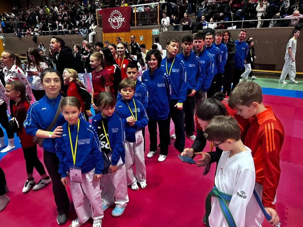 Sportlerinnen und Sportler unseres Teams in blauen Vereinsjacken auf der Matte bei der Golden Roof Open 2026