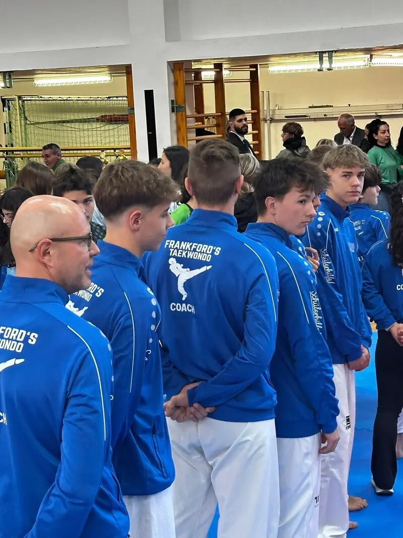Unser Team von hinten, auf den blauen Jacken die Aufschrift „Frankford's Taekwondo“, auf mehreren davon „Coach“