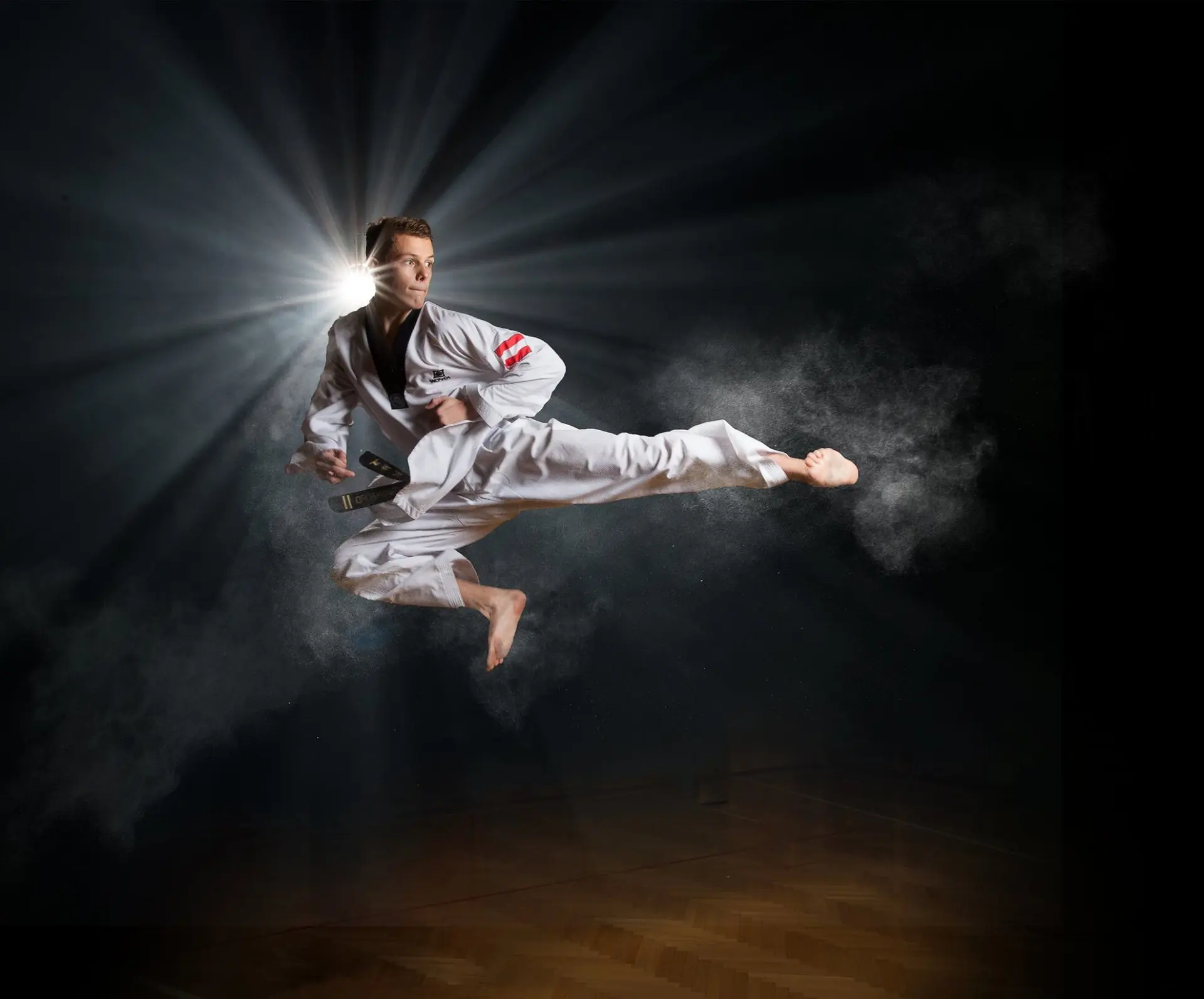 Taekwondoka im weißen Dobok bei einem gesprungenen Seitkick